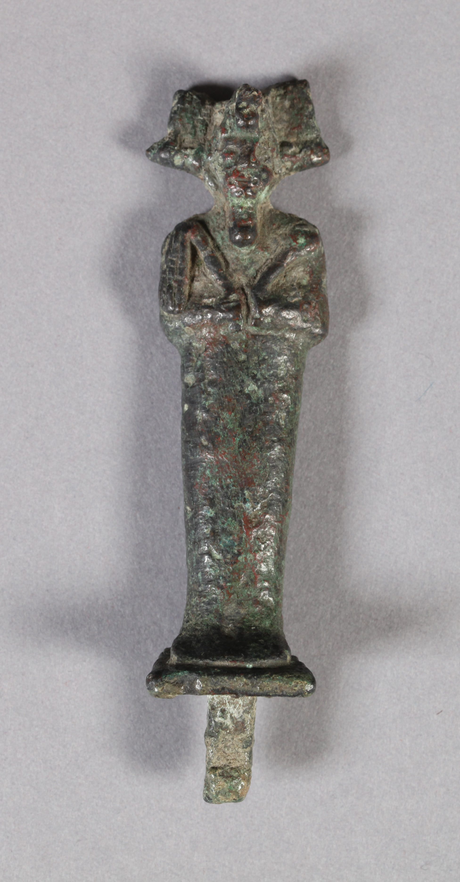 AN EGYPTIAN CAST BRONZE FIGURE OF OSIRIS with arms crossed, carrying crook and flail, ornate