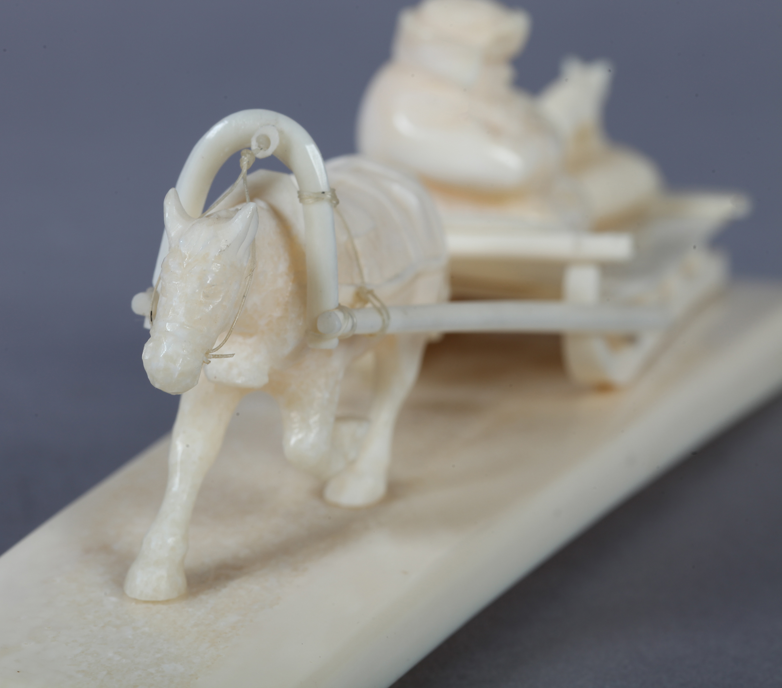 A WALRUS TUSK CARVING OF A HORSE pulling a low sledge, figure and fox on deck, tapered tusk fragment - Image 3 of 3