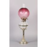 AN EDWARD VII SILVER PLATED OIL LAMP with hob nail cut reservoir and cranberry glass shade, the