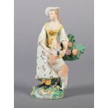 AN EARLY 19TH CENTURY YORKSHIRE FIGURE OF A WOMAN placing a floral garland around the neck of a