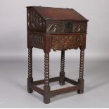 A LATE 17TH CENTURY OAK BIBLE BOX with hinged sloping front, the sides and front carved with scrolls