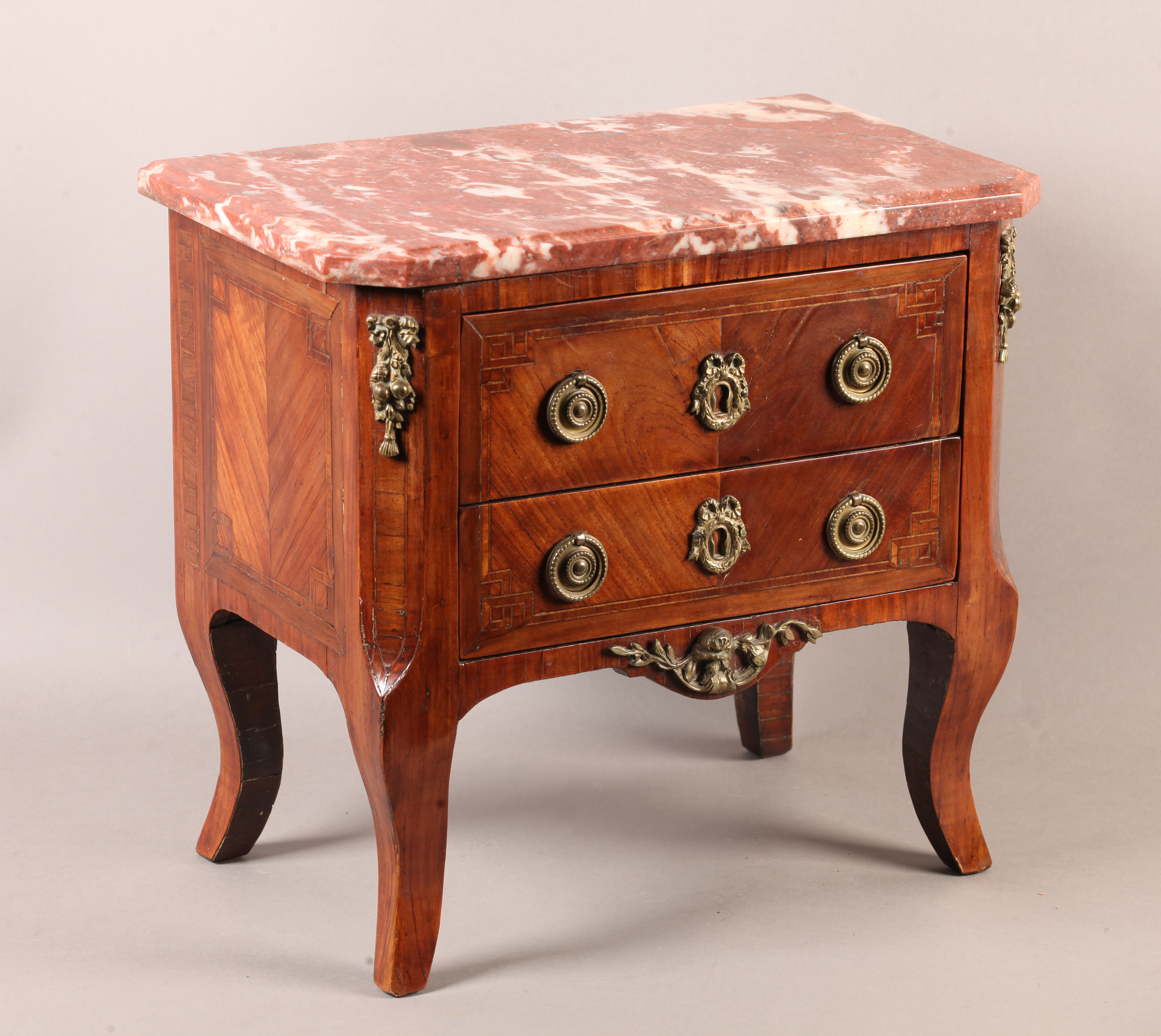 A LOUIS XVI STYLE MINIATURE MAHOGANY VENEERED COMMODE with veined rosso marble moulded top above two