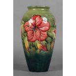 A MOORCROFT HIBISCUS VASE, ovoid painted and tubelined in deep pink against a green to blue