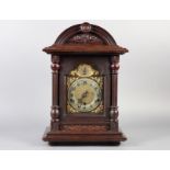 AN EDWARD VII MAHOGANY STAINED MANTEL CLOCK with arched case, the cornice with central roundel above
