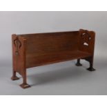 AN OAK ARTS AND CRAFTS BOOK TROUGH with plain shelf and back, the sides pierced with stylised