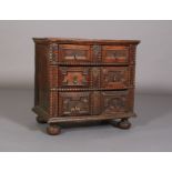 AN OAK DWARF CHEST OF THREE HEIGHTS in the 17th century style, having three graduated twin cushion