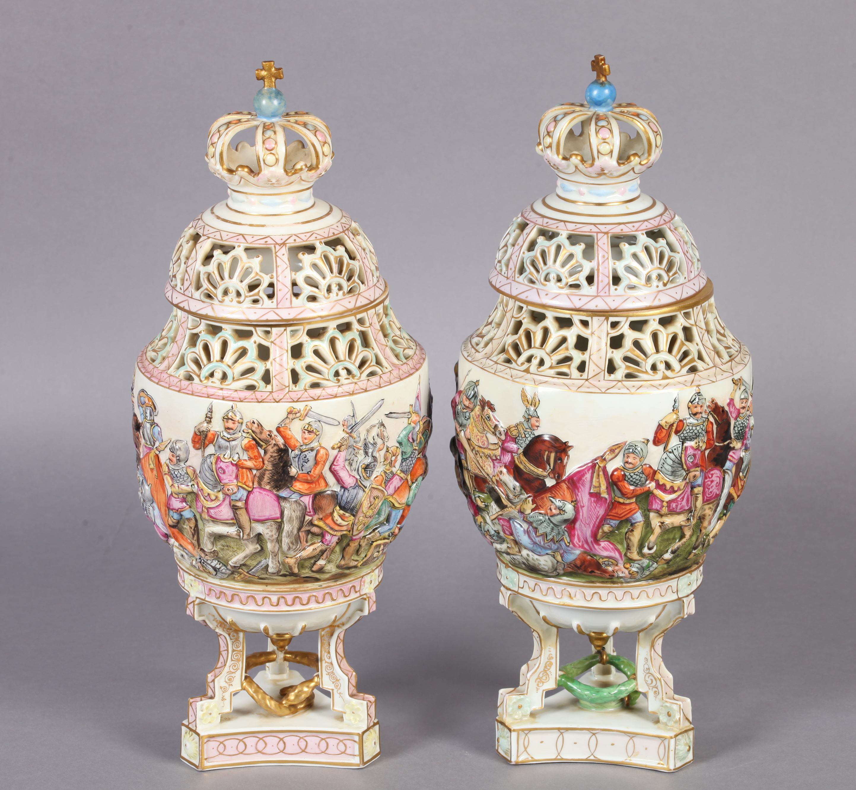A PAIR OF LATE 19TH CENTURY NAPLES DOCCIA VASES AND COVERS of urn form, relief moulded with battle