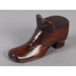 A LARGE CARVED WOODEN TABLE SNUFF in the form of a shoe with brass eyelet detail, the sliding top