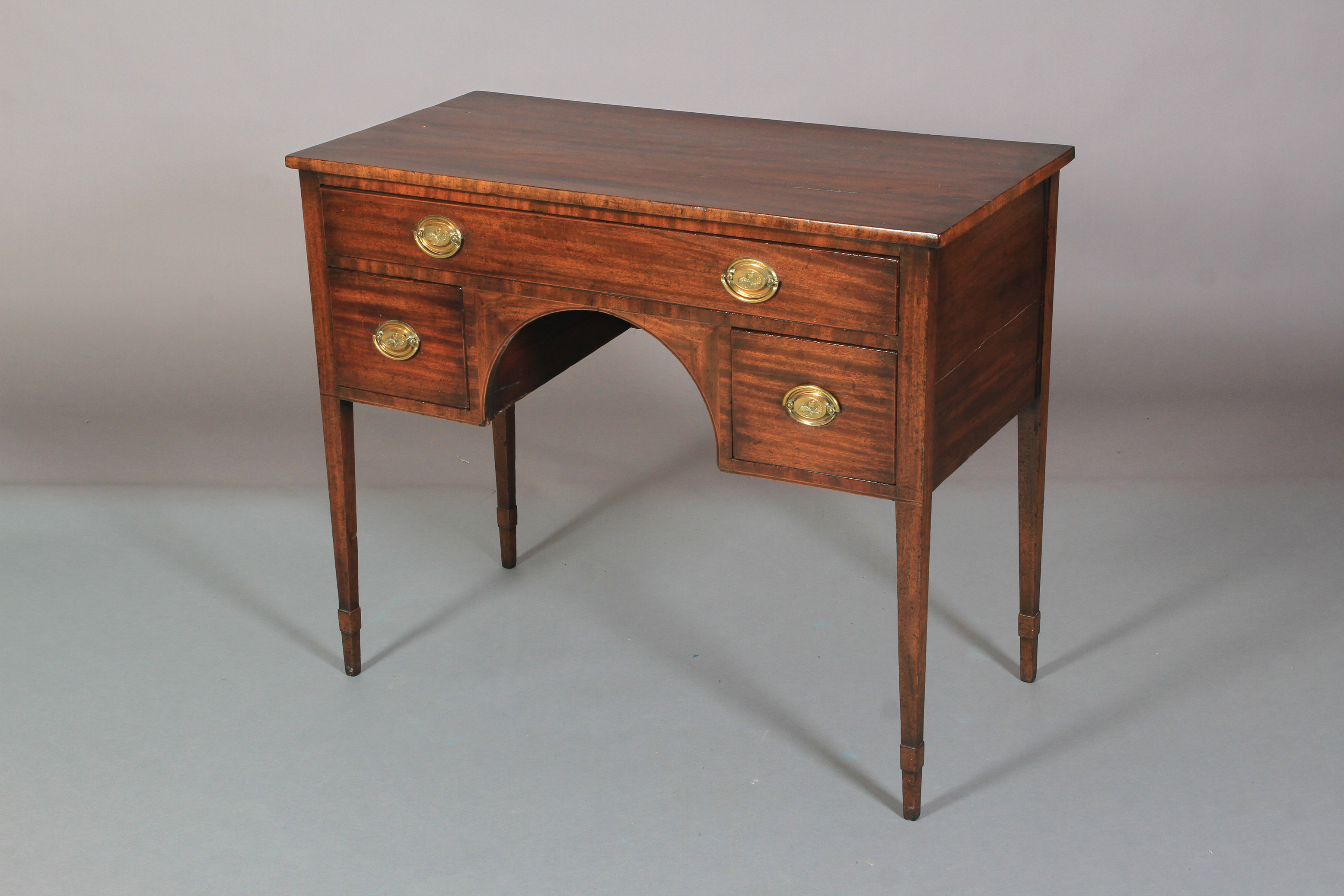 AN EARLY 19TH CENTURY MAHOGANY SIDE TABLE, having a drawer across above an arched apron flanked by a