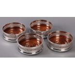 AN ELIZABETH II SET OF FOUR SILVER WINE COASTERS, of pierced design, 13cm diameter