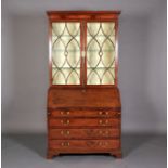 A GEORGE III MAHOGANY BUREAU-BOOKCASE, having a moulded cornice above two tracery glazed doors,