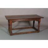 A 19TH CENTURY OAK DINING TABLE, rectangular, having a planked top, carved frieze, scroll angle