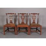 A SET OF THREE 18TH CENTURY MAHOGANY DINING CHAIRS, each having a serpentine top rail carved with