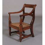 A CHILD'S EARLY 19TH CENTURY MAHOGANY CHAIR, bar top rail and tie rail, bergere caned seat on turned