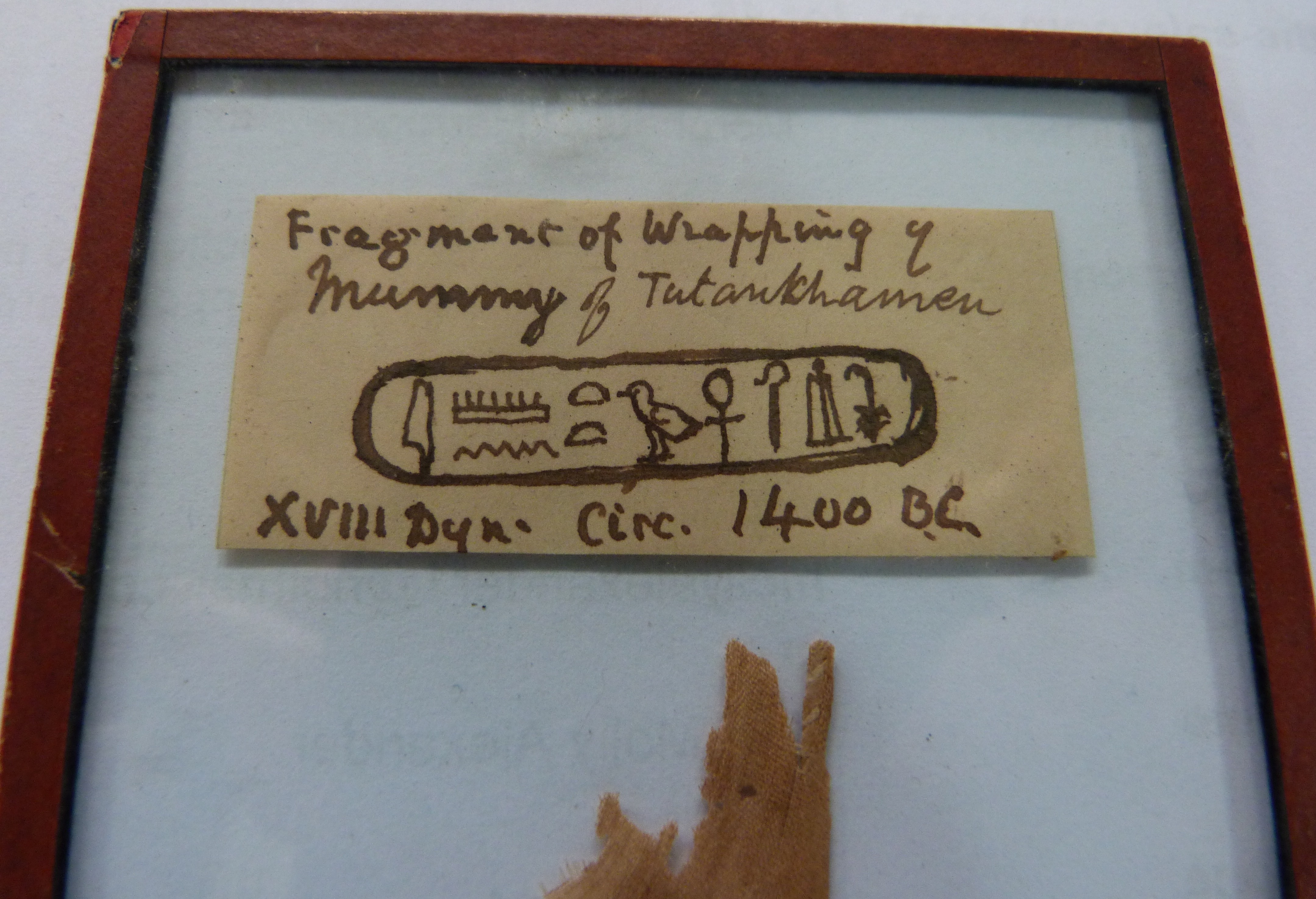 A 'FRAGMENT OF WRAPPING OF MUMMY OF TUTANKHAMEN XVIII DYN, CIRC 1400BC', glass panel with red - Image 3 of 4