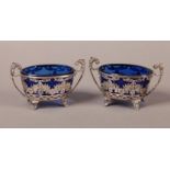 A PAIR OF VICTORIAN SILVER OPEN SALTS, oval outline with leaf scroll handles, the body pierced
