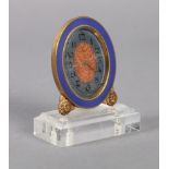 TIFFANY & CO - an ormolu and blue enamel oval bedside clock, the dial painted to the centre in red
