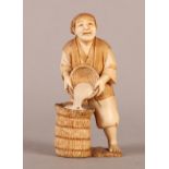 A 19TH CENTURY JAPANESE IVORY OKIMONO OF A FARMER pouring grain into a sack, signed to red seal to
