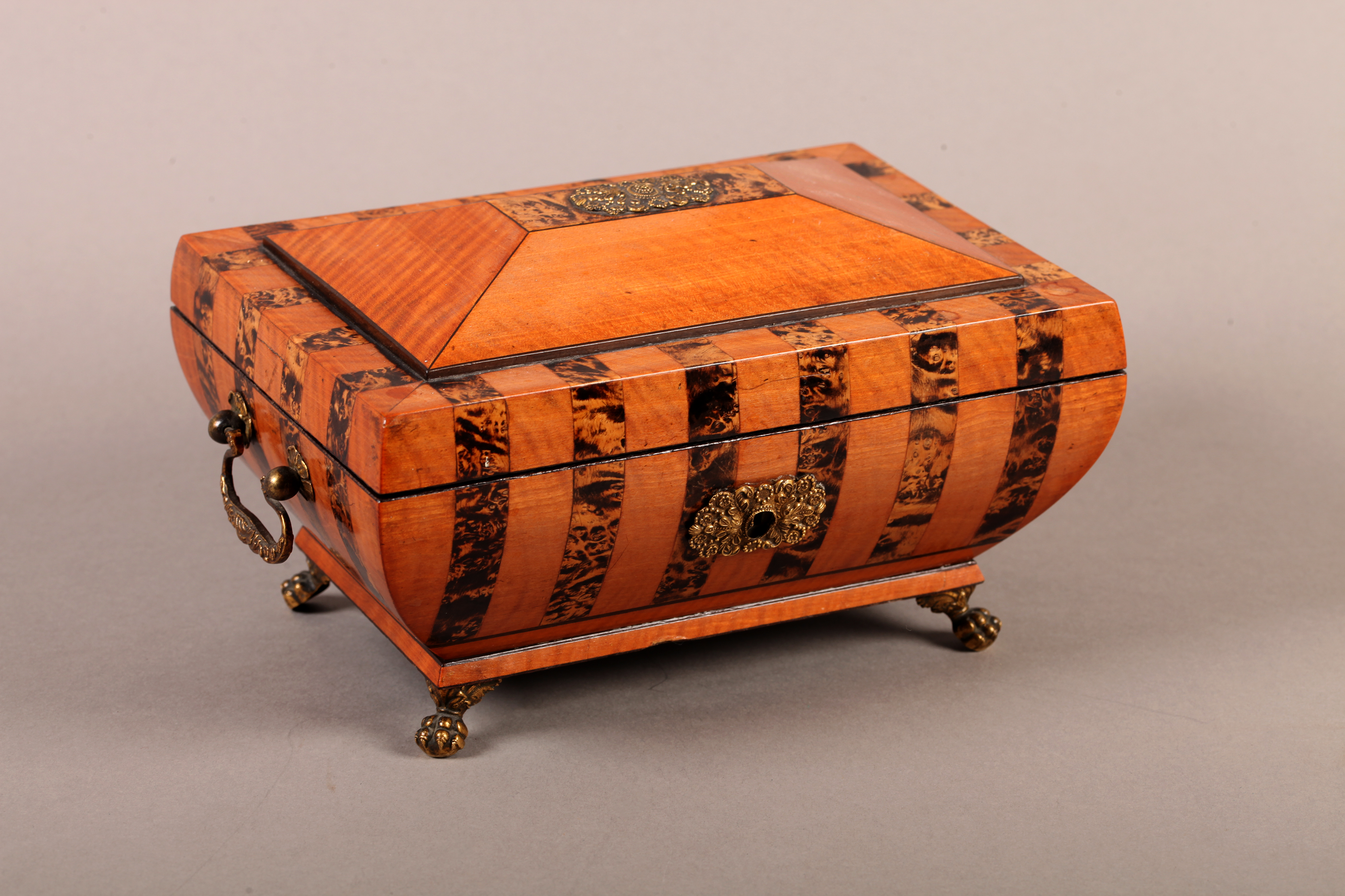 A REGENCY SATINWOOD AND BURR WALNUT BANDED JEWEL BOX OF SARCOPHAGUS SHAPE, velvet lined, with gilt