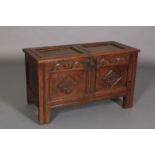 A LATE 17TH OAK BOARDED CHEST having a twin indented panel top above a frieze carved with leaf