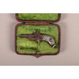 AN EARLY 20TH CENTURY NOVELTY PINFIRE PISTOL WATCH FOB the grip chased with hunting scenes, in