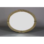 A LATE 19TH CENTURY GILT METAL FRAMED OVAL WALL MIRROR, the frame embossed with band of harebells