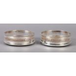 AN ELIZABETH II PAIR OF SILVER WINE COASTERS of pierced design with beaded rims 13cm