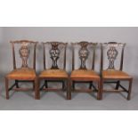 A SET OF FOUR 18TH CENTURY MAHOGANY DINING CHAIRS, each having a serpentine top rail carved with