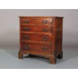 A GEORGE III MAHOGANY DWARF CHEST, having four graduated drawers with cast swing handles, reeded