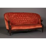 A VICTORIAN MAHOGANY BUTTON-BACK CURVED SOFA, serpentine seat, the arms boldly carved with animal
