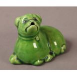 A LATE 19TH CENTURY GREEN FAIENCE FIGURE OF A RECUMBENT DOG, with open mouth, possibly