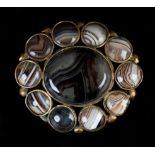 A VICTORIAN AGATE SET BROOCH in gilt base metal, collet set to the centre with an oval cabochon