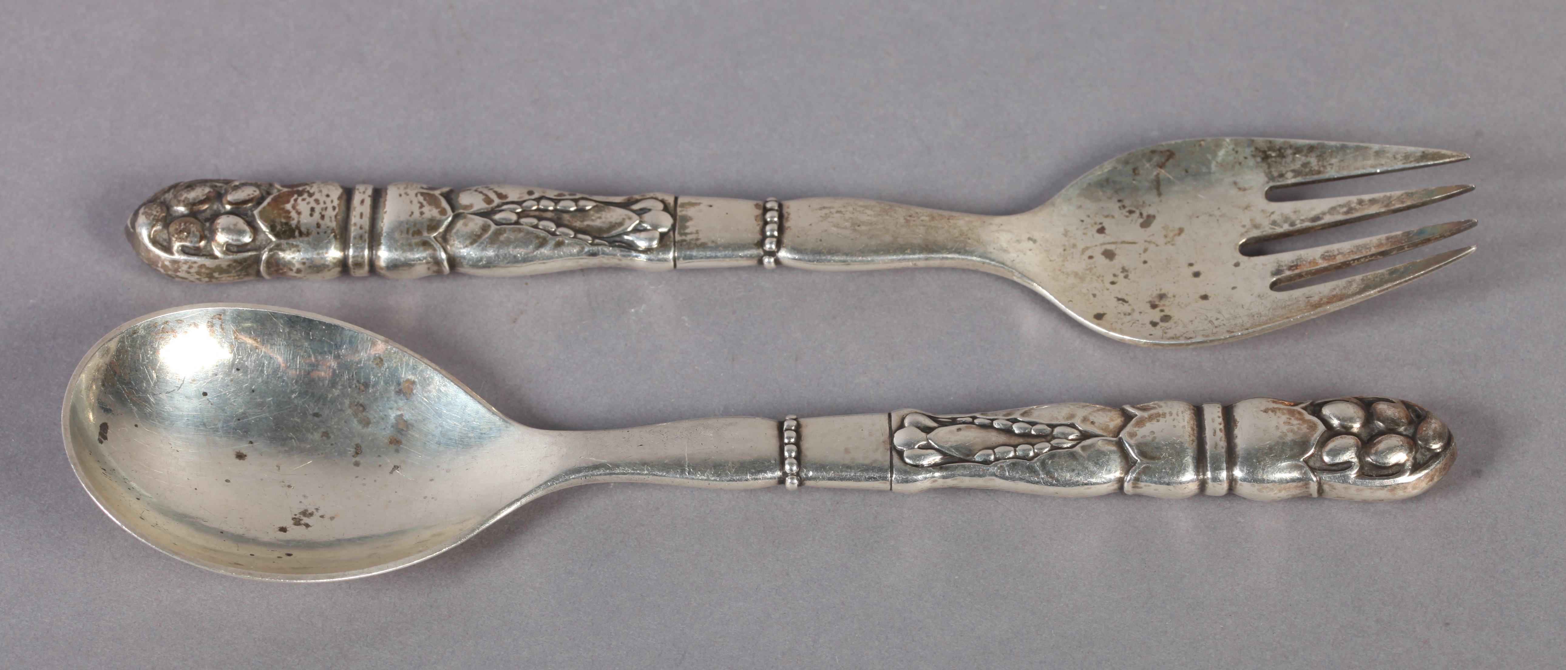 GEORG JENSEN, DENMARK, a pair of .925 Sterling silver salad servers, the handles cast with seed pods