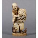 A 19TH JAPANESE IVORY OKIMONO of a farmer about to catch his chickens with a wicker basket, on an