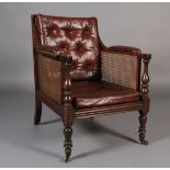 A POST REGENCY MAHOGANY FRAMED LIBRARY BERGERE ARM CHAIR having a moulded frame, baluster turned
