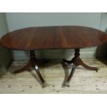 A regency style mahogany dining table with d-shaped ends and additional leaf supported on turned