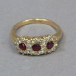 A ruby and diamond dress ring, the three circular faceted rubies a/f set in line within a surround