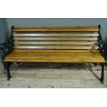 A reproduction cast metal slatted wooden garden seat with foliate scroll ends, 164cm wide