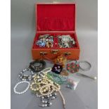 A jewellery box containing costume jewellery including, paste brooches and rings, earrings, silver
