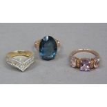 Three dress rings in silver gilt variously set with oval faceted amethyst, circular faceted and