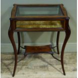 An Edwardian inlaid satinwood serpentine shaped bijouterie table, the glazed top with border of