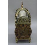 A reproduction brass lantern clock of conventional form, the brass chaptering with Roman numerals,