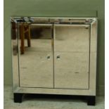 A mirrored cupboard enclosed by a pair of doors on ebonised bracket feet, 80cm wide x 88cm high