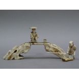 A Japanese ivory carving of two fishermen on a bridge, 15cm wide, late Meiji period