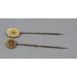 Two Victorian tie pins in 9ct gold, the circular head set with a cabochon coral and the engraved