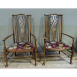 A pair of stained beech elbow chairs with pierced waisted splats, swept arms and upholstered