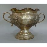 A two handled pedestal cup having a wavy rim above a lapette border and a continuous band of dancing