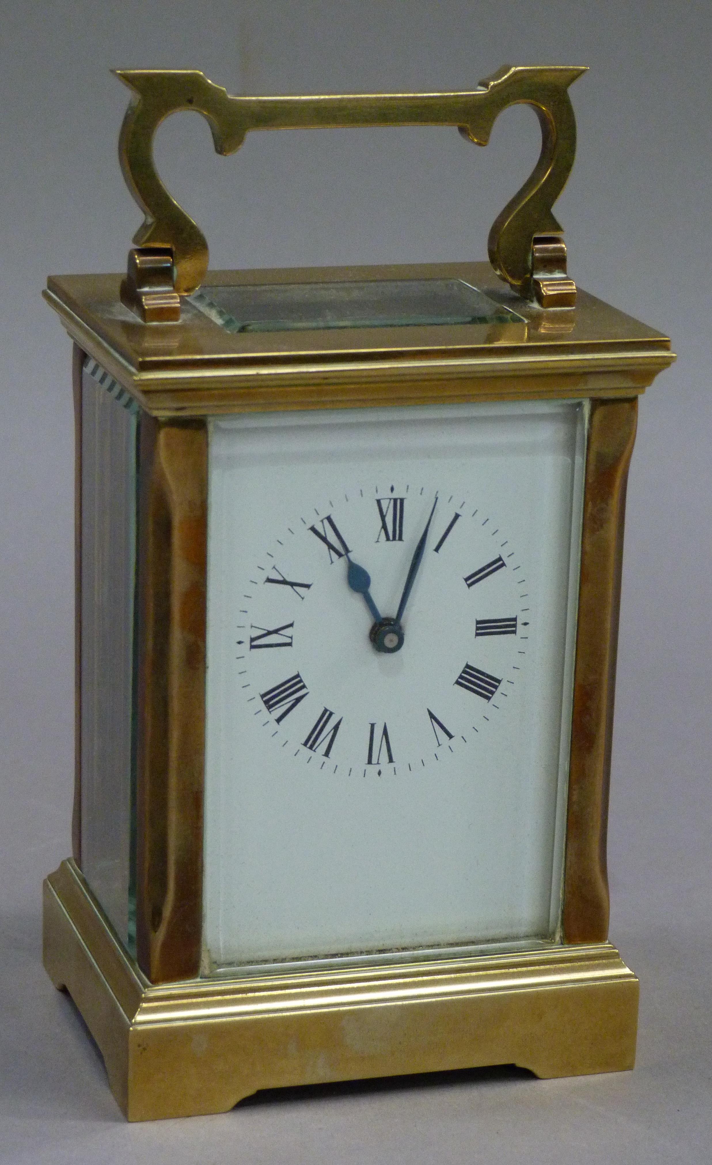 A brass carriage clock the white enamelled dial having black Roman numerals complete with key, 15.