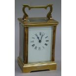 A brass carriage clock the white enamelled dial having black Roman numerals complete with key, 15.