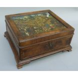 A walnut jewel casket interior lined in blue velvet on ogee bracket feet the lid inset with a